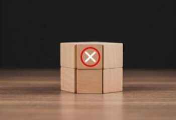 71523067-de-madeira-blocos-com-uma-vermelho-circulado-x-simbolo-significando-rejeicao-negacao-cancelamento-ou-erro-em-uma-de-madeira-mesa-contra-uma-sombrio-fundo-foto