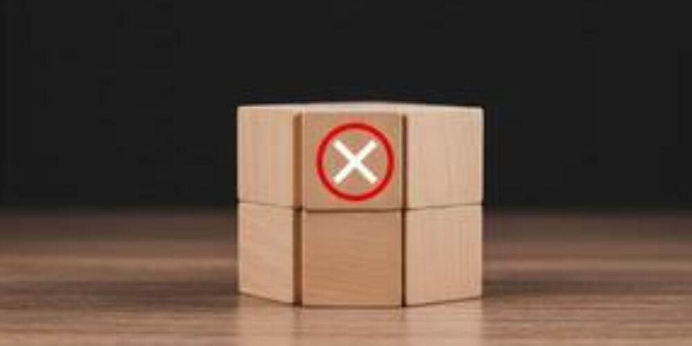 71523067-de-madeira-blocos-com-uma-vermelho-circulado-x-simbolo-significando-rejeicao-negacao-cancelamento-ou-erro-em-uma-de-madeira-mesa-contra-uma-sombrio-fundo-foto