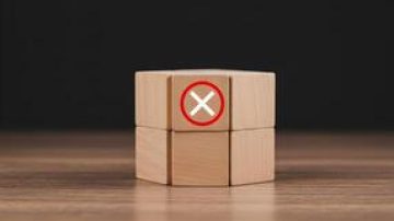 71523067-de-madeira-blocos-com-uma-vermelho-circulado-x-simbolo-significando-rejeicao-negacao-cancelamento-ou-erro-em-uma-de-madeira-mesa-contra-uma-sombrio-fundo-foto
